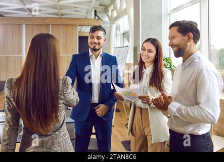 Geschäftsleute, die im Büro stehen und erfolgreich die Hände schütteln, um das Meeting zu beenden. Stockfoto