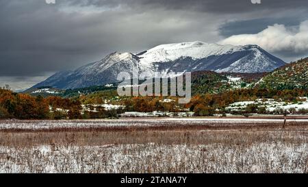 Die schneebedeckten Wiesen von Piano Cerreto und die Wälder mit den Herbstfarben des Bosco di Sant'Antonio. Im Hintergrund Mount Morrone. Abruzzen Stockfoto