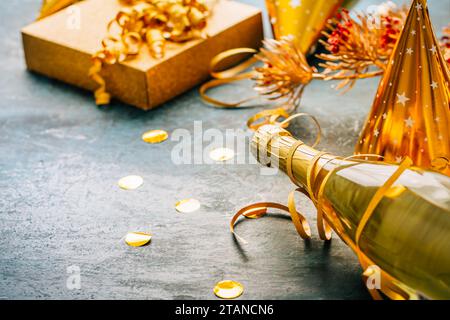 Frohe Neujahrsfeier, Flasche Champagner, helle Lichter und Geschenke Stockfoto