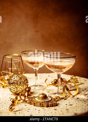 Frohe Neujahrsfeier, zwei Gläser Champagner, Streamer und Ornamente Stockfoto