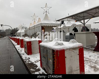 02. Dezember 2023, Hamburg: Entlang einer Straße vor einem Weihnachtsmarkt werden rot-weiße Betonblöcke errichtet. Nach den jüngsten Festnahmen wegen angeblicher Planung von Terroranschlägen auf Weihnachtsmärkten hält das Hamburger Innenministerium die Bedrohung für weiterhin hoch. Nach dem Lkw-Angriff auf den Berliner Breitscheidplatz im Dezember 2016, bei dem zwölf Menschen ums Leben kamen, wurden die Hamburger Weihnachtsmärkte mit Betonsteinen gesichert. An einigen Stellen wurden jetzt einziehbare Schiffspoller installiert (siehe dpa „Sicherheit auf Weihnachtsmärkten – Autorität: Keine spezifische Bedrohung“) Foto: Thomas Stockfoto