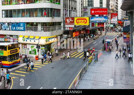 Central, Hongkong - 21. Juli 2009: Queen Victoria Street und Queen's Road Central. Geschäftige Einkaufskreuzung in der Nähe der mittleren erhöhten Rolltreppe Stockfoto