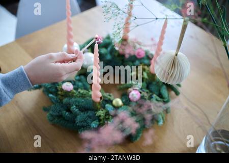 Berlin, Deutschland. Dezember 2023. Ein Junge zündet die erste Kerze an einem dekorierten Adventskranz an. Annette Riedl/dpa/Alamy Live News Stockfoto