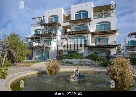 Ein Brunnen sprüht Wasser vor dem Hintergrund eines Wohnkomplexes in der Nähe des Meeres Stockfoto