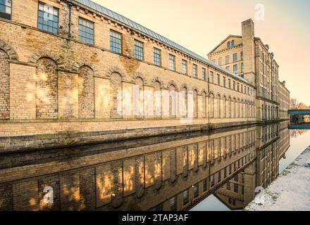 Der Kanal verläuft zwischen der New Mill (North Block) und der alten Mill Victoria Rd Saltaire ..... a.. UNESCO-Weltkulturerbe, Saltaire, West Yorkshire. Stockfoto