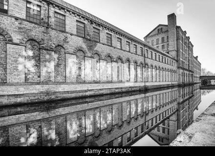 Der Kanal verläuft zwischen der New Mill (North Block) und der alten Mill Victoria Rd Saltaire ..... a.. UNESCO-Weltkulturerbe, Saltaire, West Yorkshire. Stockfoto