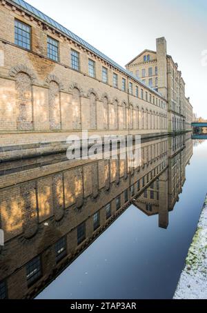 Der Kanal verläuft zwischen der New Mill (North Block) und der alten Mill Victoria Rd Saltaire ..... a.. UNESCO-Weltkulturerbe, Saltaire, West Yorkshire. Stockfoto