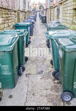 Mülltonnen in der Hintergasse zwischen Terrassengrundstücken im Modelldorf Saltaire in West Yorkshire. Stockfoto