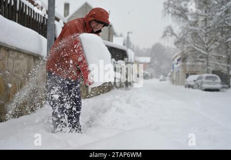 Trest, Tschechische Republik. Dezember 2023. Ein Mann entfernt Schnee von einem Pflaster in Trest, Region Jihlava, Tschechische Republik, 2. Dezember 2023. Quelle: Lubos Pavlicek/CTK Photo/Alamy Live News Stockfoto