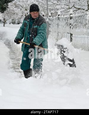 Trest, Tschechische Republik. Dezember 2023. Ein Mann entfernt Schnee von einem Pflaster in Trest, Region Jihlava, Tschechische Republik, 2. Dezember 2023. Quelle: Lubos Pavlicek/CTK Photo/Alamy Live News Stockfoto