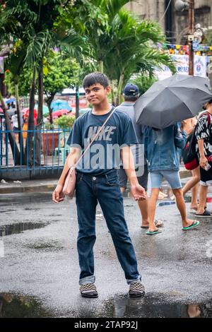 Ein junger philippinischer Junge stellt ein Kind der Kirche Santo Nino de Tondo in Tondo, Manila, auf den Philippinen. Stockfoto