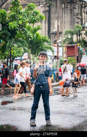 Ein junger philippinischer Junge stellt ein Kind der Kirche Santo Nino de Tondo in Tondo, Manila, auf den Philippinen. Stockfoto