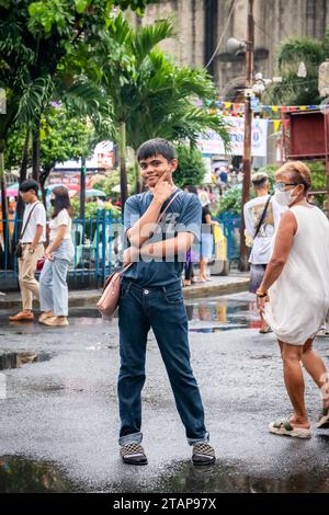 Ein junger philippinischer Junge stellt ein Kind der Kirche Santo Nino de Tondo in Tondo, Manila, auf den Philippinen. Stockfoto