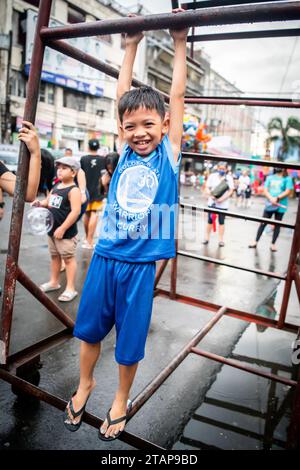 Ein junger philippinischer Junge spielt auf einem Metallrahmen in Tondo, Manila, den Philippinen. Stockfoto