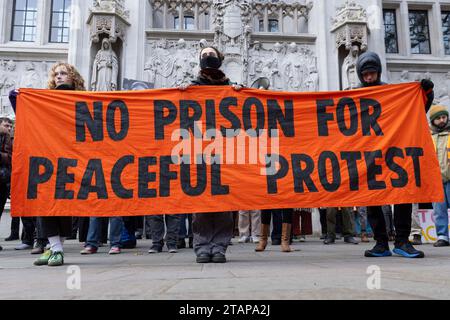 London, Großbritannien. Dezember 2023. Halten Sie die Ölprotestierenden auf dem weg von New Scotland Yard zum Obersten Gerichtshof. Mindestens zwei Klimaaktivisten wurden inhaftiert. Stockfoto