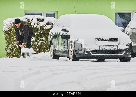 Zbysov, Tschechische Republik. Dezember 2023. Ein Mann entfernt Schnee von einem Pflaster in Zbysow, Brünn, Tschechische Republik, 2. Dezember 2023. Quelle: Patrik Uhlir/CTK Photo/Alamy Live News Stockfoto