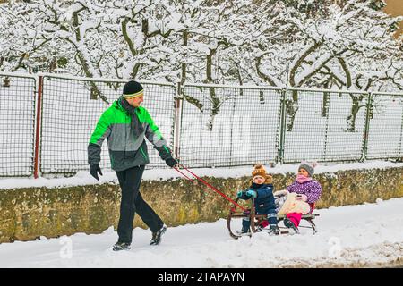 Zbysov, Tschechische Republik. Dezember 2023. Ein Mann zieht Kinder auf einem Schlitten in Zbysow, Brünn, Tschechische Republik, 2. Dezember 2023. Quelle: Patrik Uhlir/CTK Photo/Alamy Live News Stockfoto