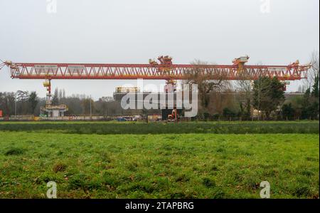 Harefield, Großbritannien. Dezember 2023. Dominique der riesige, orange Trägerkran HS2, der den nächsten Teil des Colne Valley Viaduct in Harefield baut, der neue Hochgeschwindigkeitszüge von London nach Birmingham bringen wird. Das umstrittene Hochgeschwindigkeitsbahnprojekt ist nach wie vor sehr über dem Budget. Die nördliche Phase 2 von HS2 wurde von Rishi Sunak abgesagt, aber es gibt jetzt Bedenken von Bewohnern nördlich von Birmingham, dass, wenn Labour im nächsten Jahr gewählt wird, Keir Starmer von Bürgermeister Andy Burnham angeregt wurde, Phase 2 wiederbeleben könnte. Es wurde berichtet, dass einige Personen auf der unterdrückten HS2-Strecke b Stockfoto