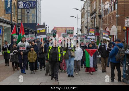 Southend on Sea, Großbritannien. Dezember 2023. Demonstranten marschieren entlang der Southend High Street in einem friedlichen Protest, der Palästina unterstützt, mit Plakaten mit der Aufschrift „Hände weg von Al-Aqsa“ und „Stopp des Völkermords in Gaza“. Zu den Teilnehmern gehören Marshals in gut sichtbaren Westen und Personen mit palästinensischer Flagge. Pro-palästinensische Anhänger marschieren durch die Southend High Street. Penelope Barritt/Alamy Live News Stockfoto