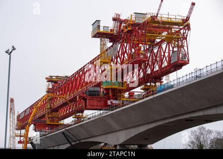 Harefield, Großbritannien. Dezember 2023. Dominique der riesige, orange Trägerkran HS2, der den nächsten Teil des Colne Valley Viaduct in Harefield baut, der neue Hochgeschwindigkeitszüge von London nach Birmingham bringen wird. Das umstrittene Hochgeschwindigkeitsbahnprojekt ist nach wie vor sehr über dem Budget. Die nördliche Phase 2 von HS2 wurde von Rishi Sunak abgesagt, aber es gibt jetzt Bedenken von Bewohnern nördlich von Birmingham, dass, wenn Labour im nächsten Jahr gewählt wird, Keir Starmer von Bürgermeister Andy Burnham angeregt wurde, Phase 2 wiederbeleben könnte. Es wurde berichtet, dass einige Personen auf der unterdrückten HS2-Strecke b Stockfoto