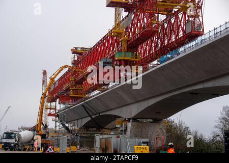 Harefield, Großbritannien. Dezember 2023. Dominique der riesige, orange Trägerkran HS2, der den nächsten Teil des Colne Valley Viaduct in Harefield baut, der neue Hochgeschwindigkeitszüge von London nach Birmingham bringen wird. Das umstrittene Hochgeschwindigkeitsbahnprojekt ist nach wie vor sehr über dem Budget. Die nördliche Phase 2 von HS2 wurde von Rishi Sunak abgesagt, aber es gibt jetzt Bedenken von Bewohnern nördlich von Birmingham, dass, wenn Labour im nächsten Jahr gewählt wird, Keir Starmer von Bürgermeister Andy Burnham angeregt wurde, Phase 2 wiederbeleben könnte. Es wurde berichtet, dass einige Personen auf der unterdrückten HS2-Strecke b Stockfoto