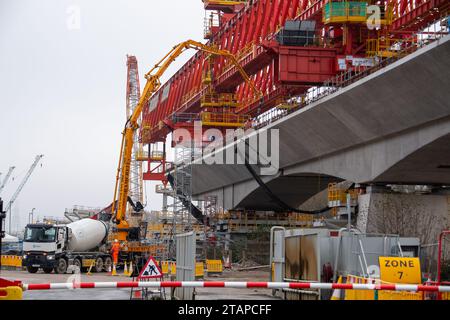 Harefield, Großbritannien. Dezember 2023. Dominique der riesige, orange Trägerkran HS2, der den nächsten Teil des Colne Valley Viaduct in Harefield baut, der neue Hochgeschwindigkeitszüge von London nach Birmingham bringen wird. Das umstrittene Hochgeschwindigkeitsbahnprojekt ist nach wie vor sehr über dem Budget. Die nördliche Phase 2 von HS2 wurde von Rishi Sunak abgesagt, aber es gibt jetzt Bedenken von Bewohnern nördlich von Birmingham, dass, wenn Labour im nächsten Jahr gewählt wird, Keir Starmer von Bürgermeister Andy Burnham angeregt wurde, Phase 2 wiederbeleben könnte. Es wurde berichtet, dass einige Personen auf der unterdrückten HS2-Strecke b Stockfoto
