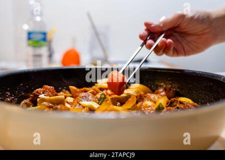 Bei mir zu Hause schneide ich das Huhn mit Kartoffeln, Karotten, Zwiebeln und Paprika, füge rote Pfefferpaste, Sojasauce und Stärkesirup hinzu und koche es dann Stockfoto