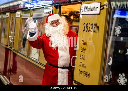 Berlin, Deutschland. Dezember 2023. Ein Mann im Weihnachtsmannkostüm winkt aus dem Weihnachtszug des Vereins historische S-Bahn. Der Weihnachtszug fährt nach mehrjähriger Pause wieder durch Berlin. Quelle: Fabian Sommer/dpa/Alamy Live News Stockfoto