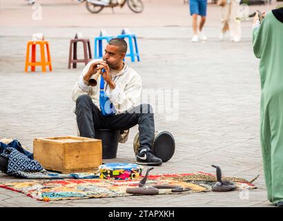 Marrakesch, Marokko, 8. April 2023. Ein marokkanischer Schlangenbeschwörer spielt mit seinen Schlangen auf dem Marrakesch Jemaa el-Fnaa-Platz. Stockfoto