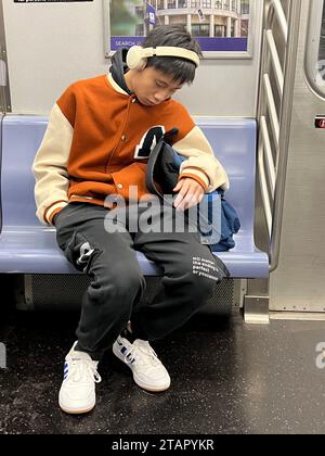 Der Schüler konnte noch mehr Schlaf vertragen, als er morgens mit dem U-Bahn-Zug von New York City zur Schule fährt. Stockfoto