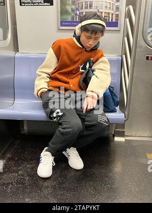 Der Schüler konnte noch mehr Schlaf vertragen, als er morgens mit dem U-Bahn-Zug von New York City zur Schule fährt. Stockfoto