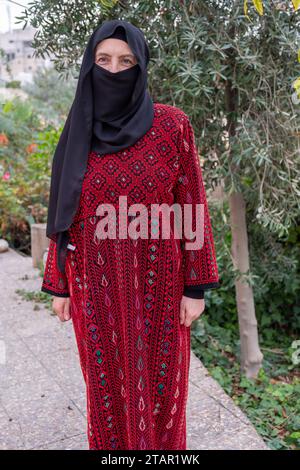 Porträt für Frau in traditioneller Kleidung im Flüchtlingslager behinde-Olivenbaum Stockfoto
