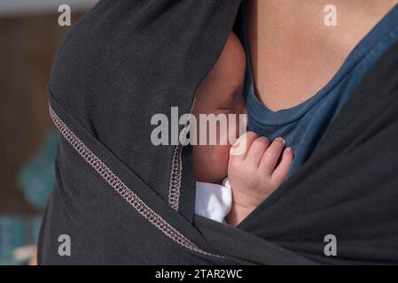 Das Baby schläft in einer Tragetasche mit seiner Mutter, Mecklenburg-Vorpommern Stockfoto