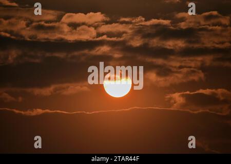 Srinagar, Indien. Dezember 2023. Die Sonne geht an einem kalten Winterabend hinter den Wolken in Srinagar, der Sommerhauptstadt von Jammu und Kaschmir, unter. (Foto: Saqib Majeed/SOPA Images/SIPA USA) Credit: SIPA USA/Alamy Live News Stockfoto