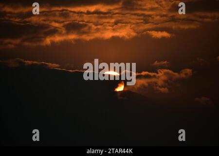 Srinagar, Indien. Dezember 2023. Die Sonne geht an einem kalten Winterabend hinter den Wolken in Srinagar, der Sommerhauptstadt von Jammu und Kaschmir, unter. (Foto: Saqib Majeed/SOPA Images/SIPA USA) Credit: SIPA USA/Alamy Live News Stockfoto