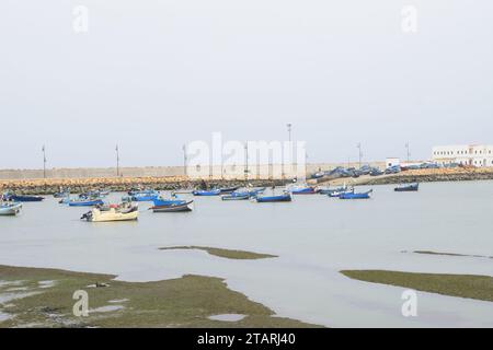 Unbearbeitetes Foto von Fischerbooten in einem Hafen bei nebeligem Wetter Stockfoto