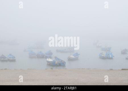 Unbearbeitetes Foto von Fischerbooten in einem Hafen bei nebeligem Wetter Stockfoto