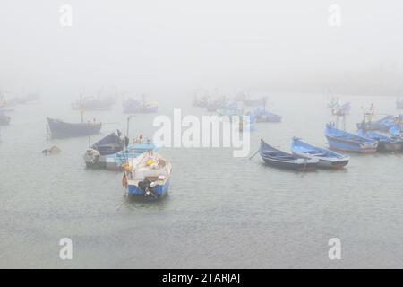 Unbearbeitetes Foto von Fischerbooten in einem Hafen bei nebeligem Wetter Stockfoto