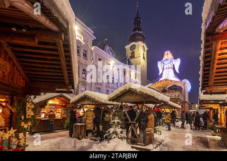 Wels: Weihnachtswelt am Stadtplatz, schneebedeckte Stände, Christkindstatue, Stadtpfarrkirche im Zentralraum, OBE Stockfoto