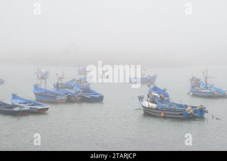 Unbearbeitetes Foto von Fischerbooten in einem Hafen bei nebeligem Wetter Stockfoto