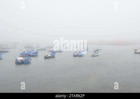 Unbearbeitetes Foto von Fischerbooten in einem Hafen bei nebeligem Wetter Stockfoto