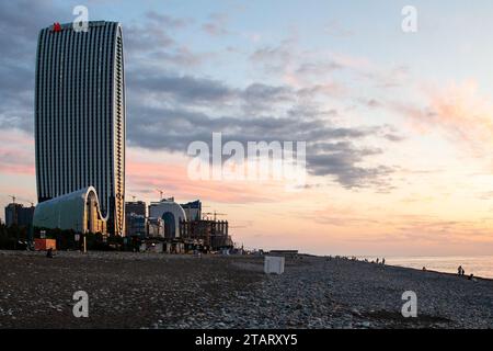 Batumi, Georgia - 19. September 2023: Blick auf den Wolkenkratzer am Strand des Schwarzen Meeres nach Sonnenuntergang in Batumi in der Herbstdämmerung Stockfoto