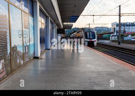 Batumi, Georgien - 22. September 2023: Passagiere gehen am Herbstmorgen zum Zug Batumi Tiflis auf dem Bahnsteig des Bahnhofs Batumi Stockfoto