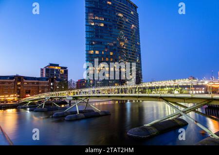 Uhren und Wolkenkratzer - Docklands in London bei Nacht Stockfoto