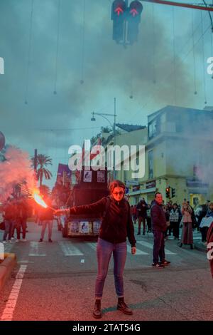 Messina, Italien. Dezember 2023. Ein Demonstrant mit einer roten Rauchbombe während des Protestes gegen den Bau der Strait Bridge, organisiert von der No Bridge Coordination in Messina. Etwa zweitausend Menschen protestierten gegen den Bau der Brücke über die Meerenge von Messina, der längsten Hängebrücke der Welt in einem Gebiet, das heftigen Winden und starken Gezeitenströmen ausgesetzt ist, in einem der Gebiete mit dem höchsten Erdbebenrisiko im Mittelmeer. Hunderttausende von Quadratmetern Land, Häuser und öffentliche Unternehmen werden enteignet. Ende 2022 war die 'Brücke, die war Stockfoto