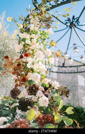 Bunte Blumen wickeln sich um einen Hochzeitsbogen Stockfoto