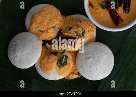 Mit Kokos-Chutney. Gedämpfter herzhafter Reiskuchen mit einem Teig fermentierter schwarzer Linsen und Reis. Serviert auf einem Bananenblatt entlang wi Stockfoto