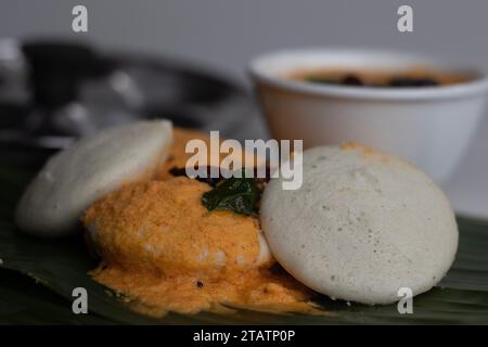 Mit Kokos-Chutney. Gedämpfter herzhafter Reiskuchen mit einem Teig fermentierter schwarzer Linsen und Reis. Serviert auf einem Bananenblatt entlang wi Stockfoto