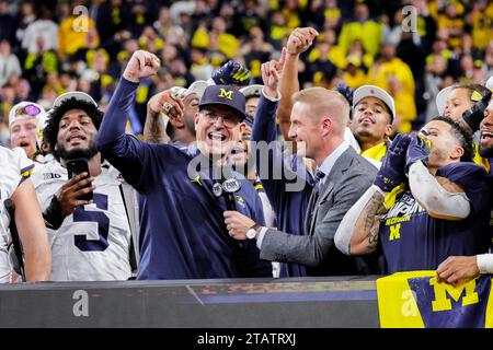 Indianapolis, Indiana, USA. Dezember 2023. JIM HARBAUGH, Cheftrainer von Michigan Wolverines, feiert auf der Bühne, nachdem er das Spiel der Big Ten Championship zwischen den Iowa Hawkeyes und den Michigan Wolverines im Lucas Oil Stadium in Indianapolis, Indiana, gewonnen hat. (Kreditbild: © Scott Stuart/ZUMA Press Wire) NUR REDAKTIONELLE VERWENDUNG! Nicht für kommerzielle ZWECKE! Stockfoto