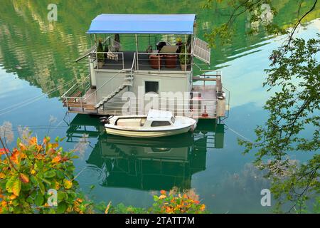 Hausboot mit kleinem Kabinenboot auf dem Perucac See - Drina Fluss, Bajina Basta, Serbien Stockfoto